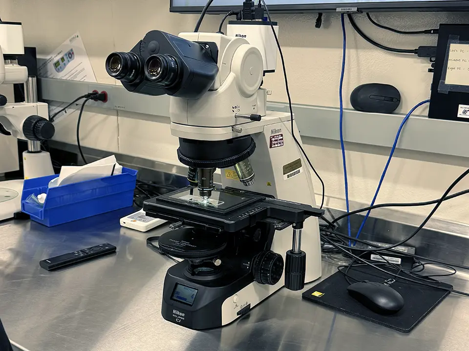 Nikon microscope on a laboratory bench with a slide mounted on its stage.