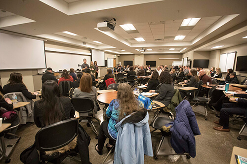 Prospective student interviewees and their families listen intently to an interest table discussion on "Life as a 1st Year Veterinary Student" with DVM Class of 2021 students Matt Schiffman, Brooke Matusiak, and Kayla Hoenert as part of the 2018 DVM Interview Day in Lynn Hall.