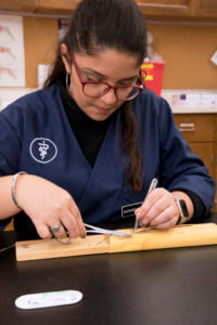 student pictured practicing sutures in Clinical Skills Lab