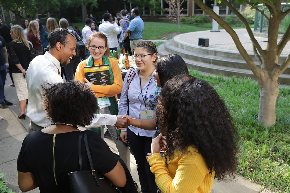 Dr. Henry Green pictured with students at Iverson Bell reception