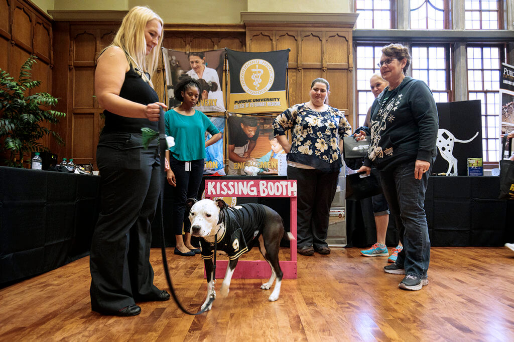 Lori Corriveau pictured with Carmella the dog and veterinary students at the Purdue Resource Fair