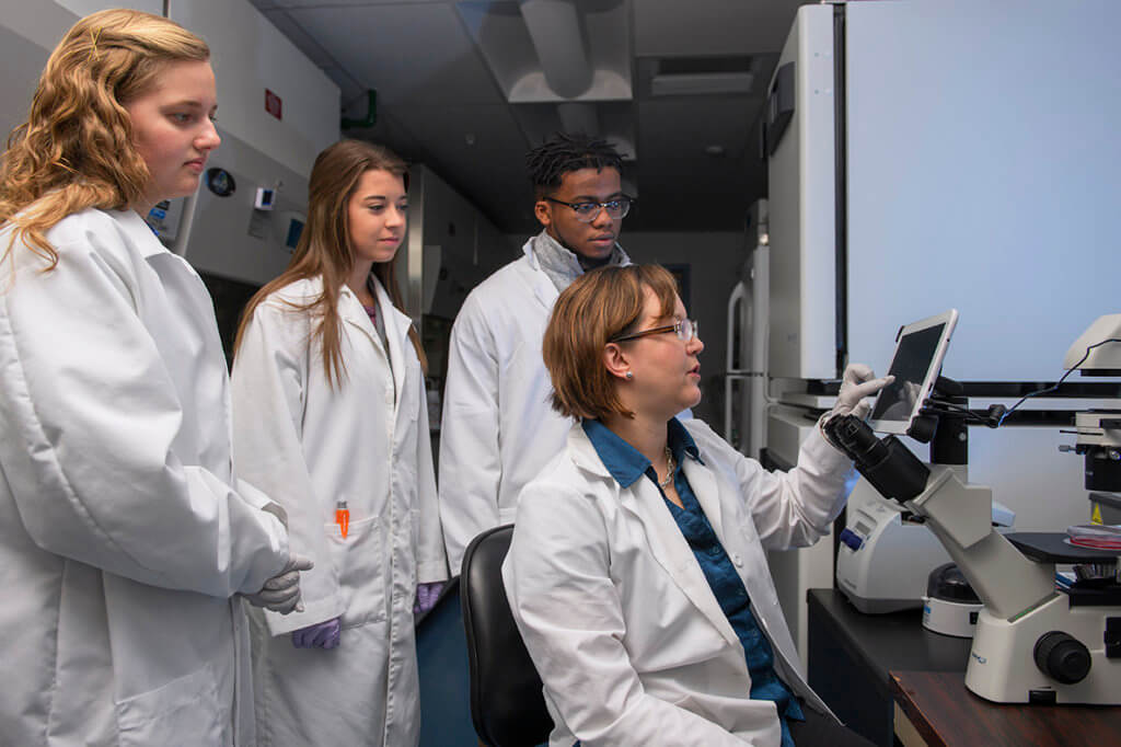 Dr. Marxa Figueiredo pictured with students in her lab