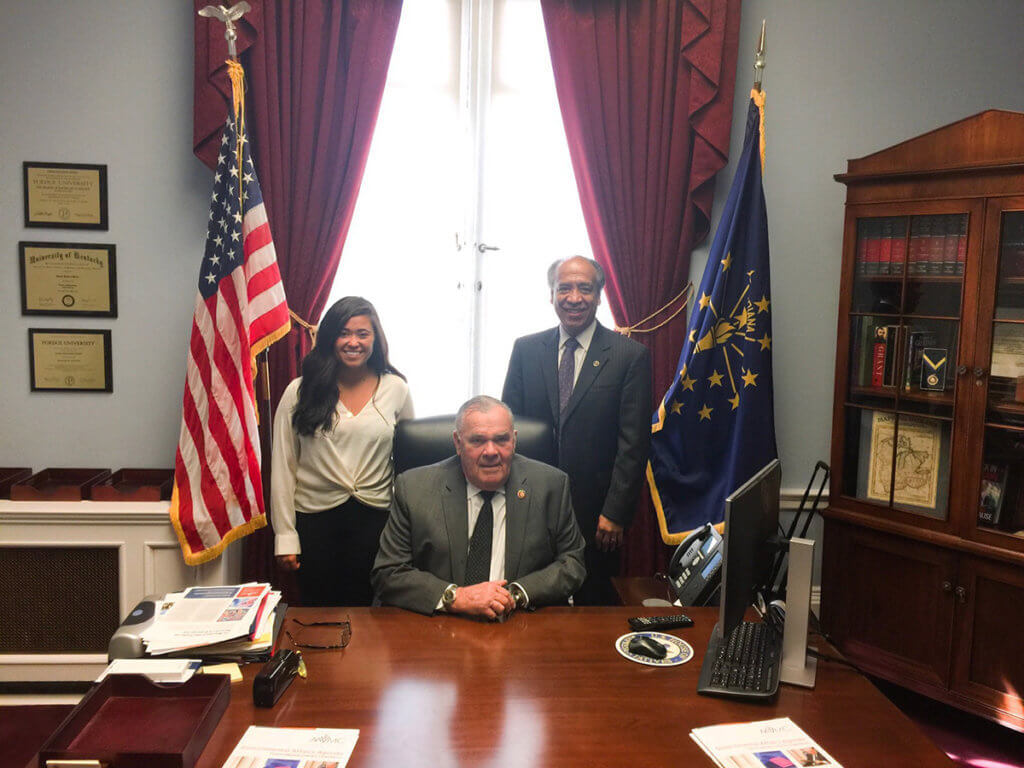 Kristi Crow and Dean Reed stand behind James Baird in his office