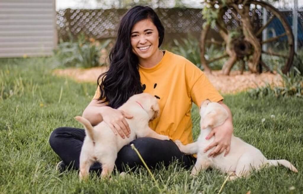 Kristi Crow pictured with puppies outside.