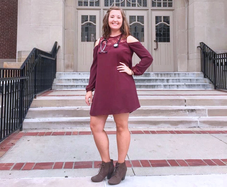 Megan Allan pictured on the steps of the Purdue Memorial Union donning her new stethoscope