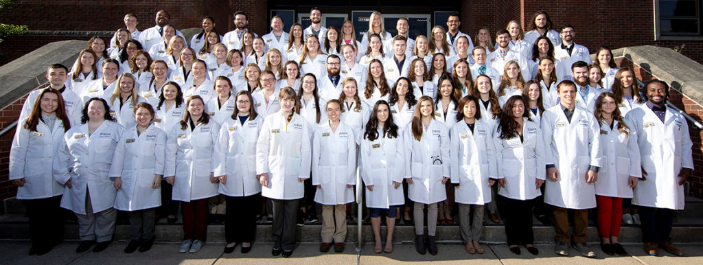 group photo of veterinary students on the steps of Lynn Hall wearing their new white coats