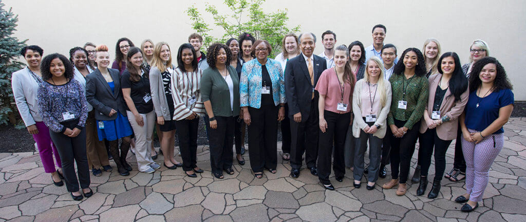 students and program organizers stand in a courtyard outside for a group photo