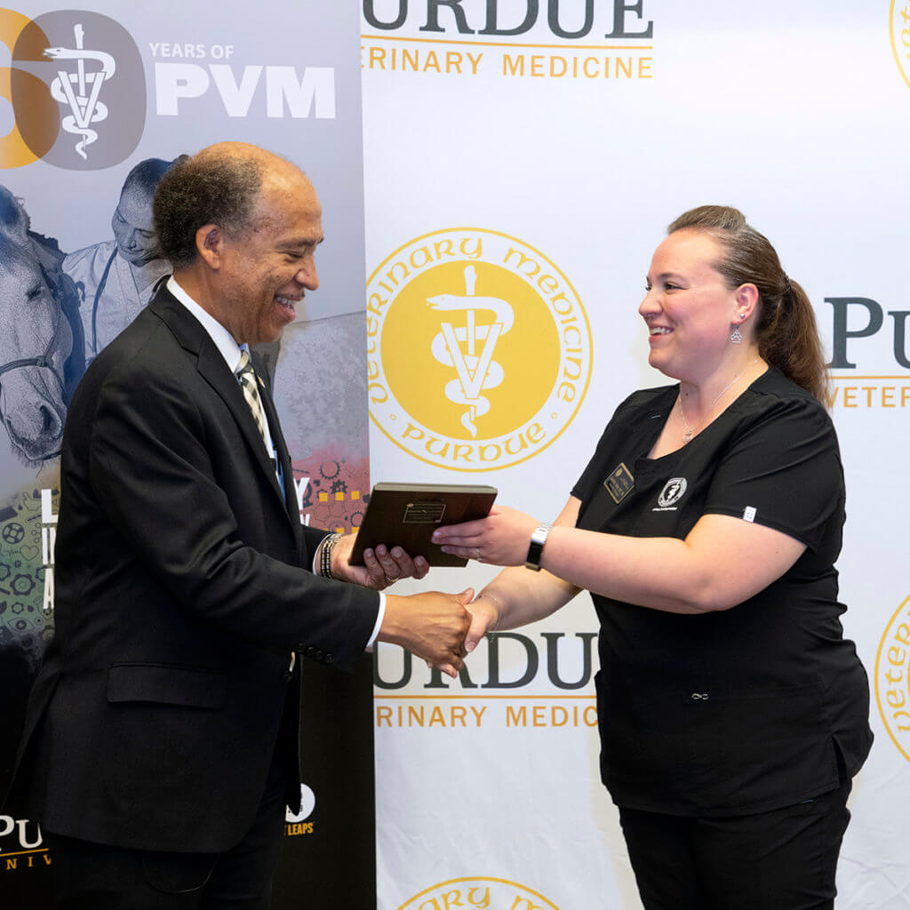 Jeannine accepts her Outstanding Staff Award plaque from Dean Reed