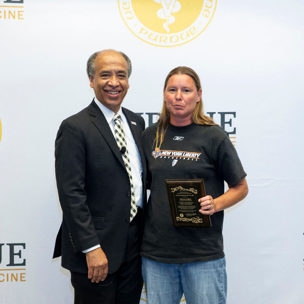 Theresa Jeffrey stands beside Dean Reed after receiving her award plaque