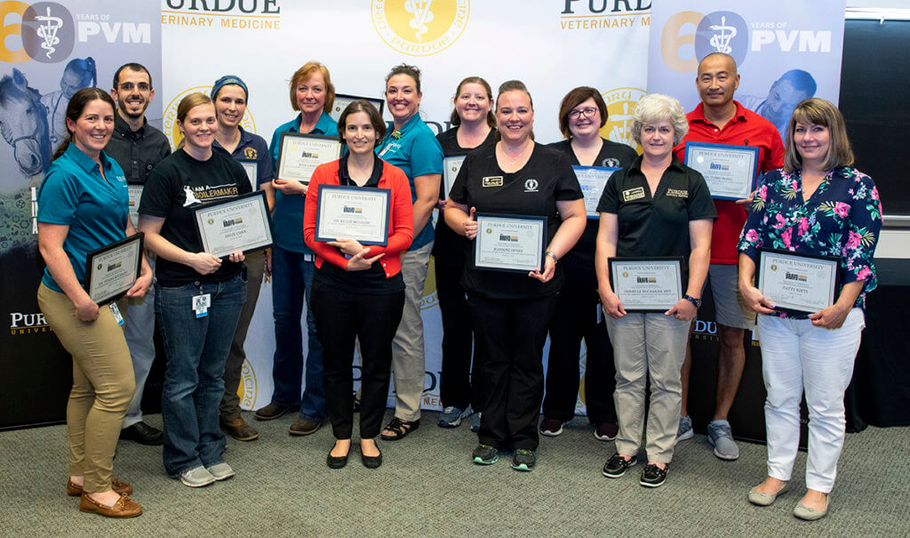 Bravo Awards recipients stand together holding their certificates with Dean Reed