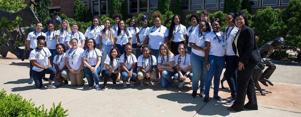 Vet Up! College participants gather for a group photo with Dr. Craig in front of the Continuum sculpture