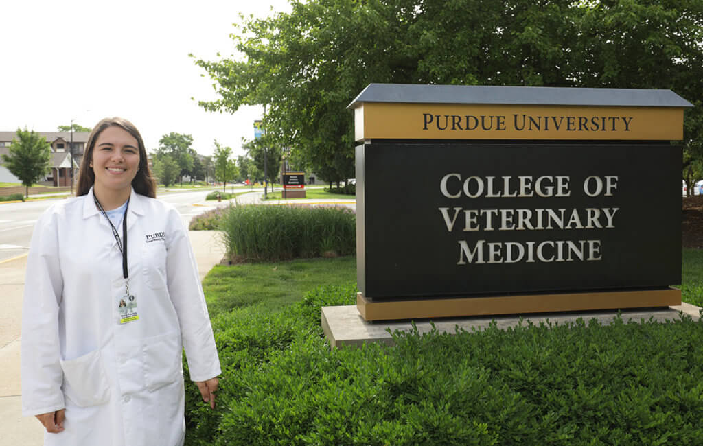 Maria stands outside of Lynn Hall in her white coat