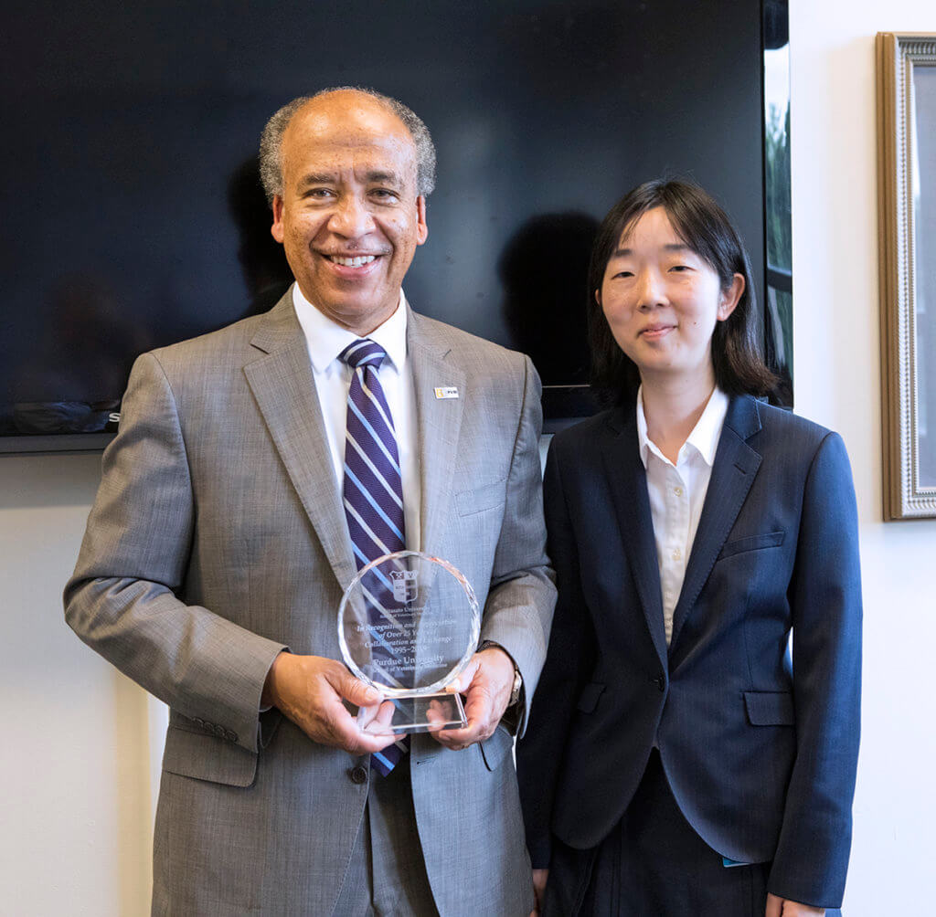 Dean Reed stands beside Dr. Yamamoto-Samejim holding a commemorative plaque