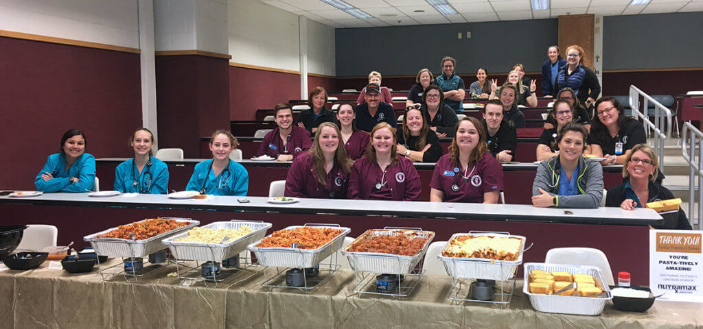 Purdue Veterinary Medicine's veterinary nurses take a group photo before a feast of pasta