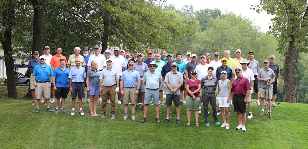 golfers join for a group photo along the golf course at Coyote Crossing