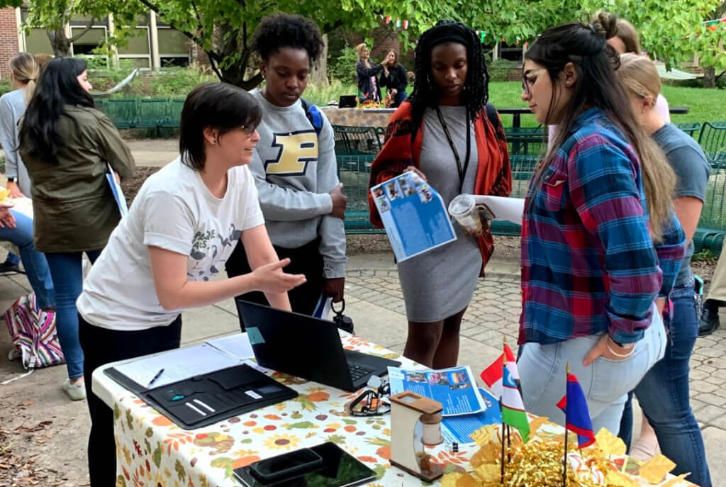 Dr. Santos speaks with students at a table at the Fall Extravaganza event in the Lynn Hall Courtyard