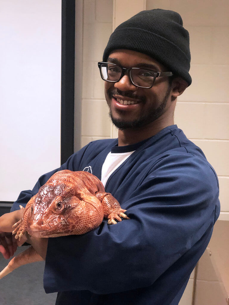 Evan holds a large red tegu lizard