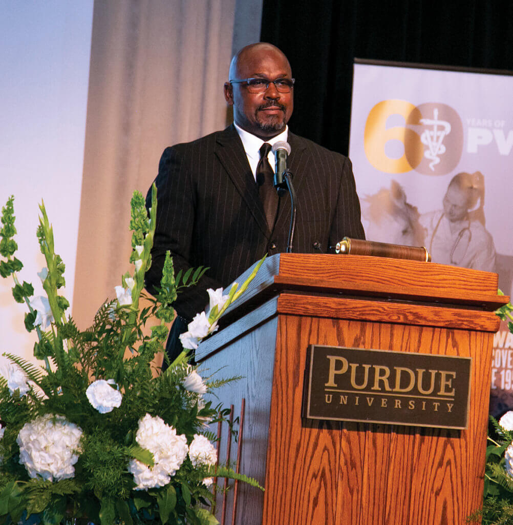 Dr. Ragland stands behind a podium addressing the crowd