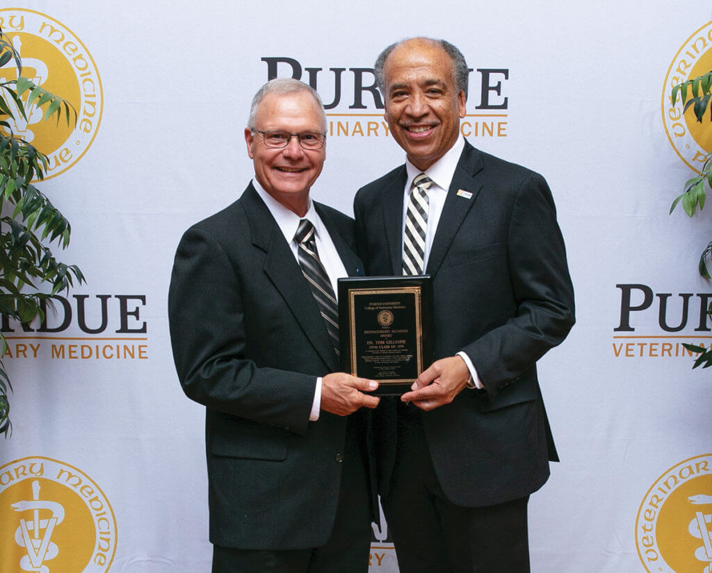 Dr. Gillespie stands beside Dean Reed holding his award plaque