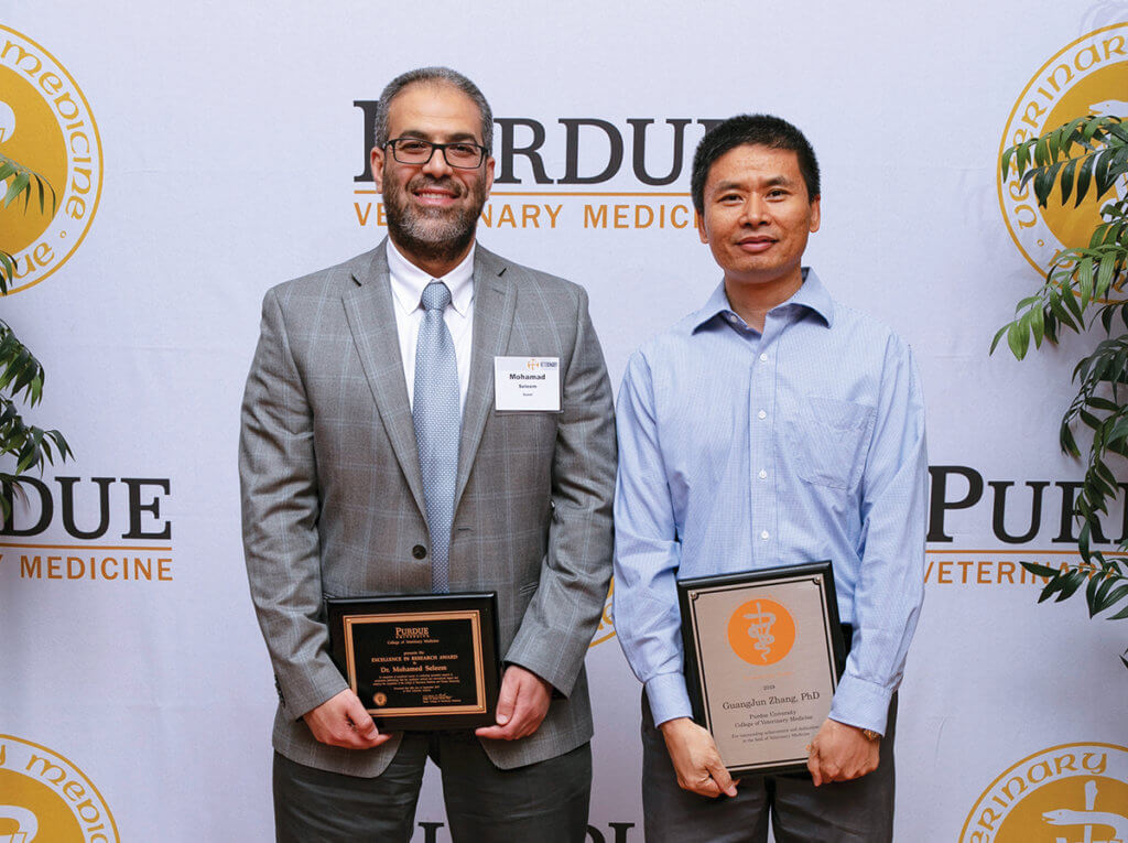 Dr. Seleem stands beside Dr. Zhang holding their respective award plaques
