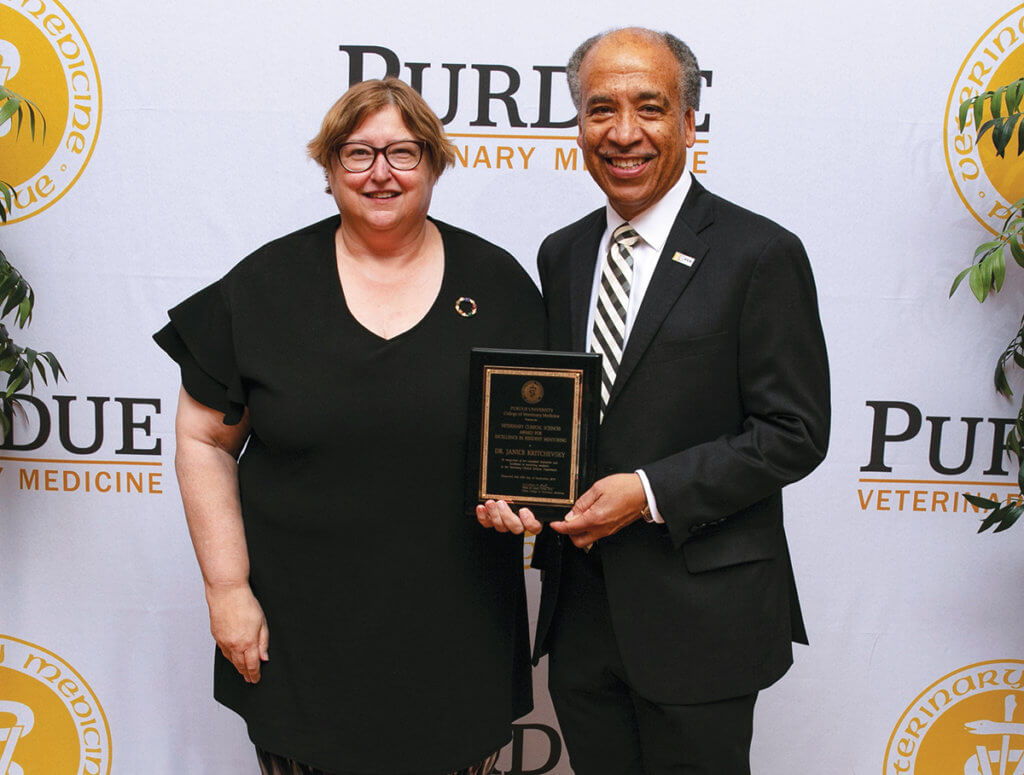 Dr. Kritchevsky stands beside Dean Reed holding her award plaque