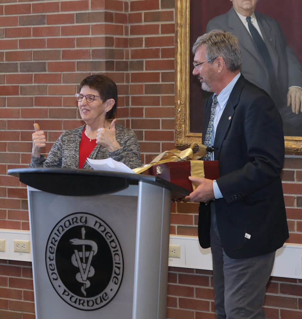 Kris gives two thumbs up to the crowd as Dr. Breur presents her with a gift