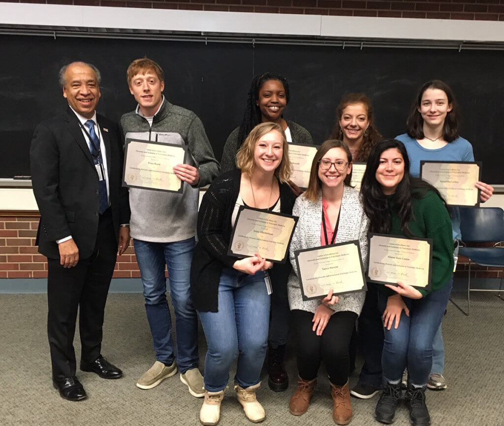 Dean Reed stands beside a group of students holding up their certificates