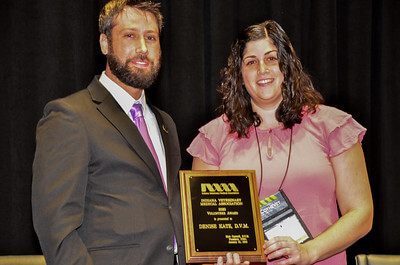 Matt and Denise stand together holding her award plaque