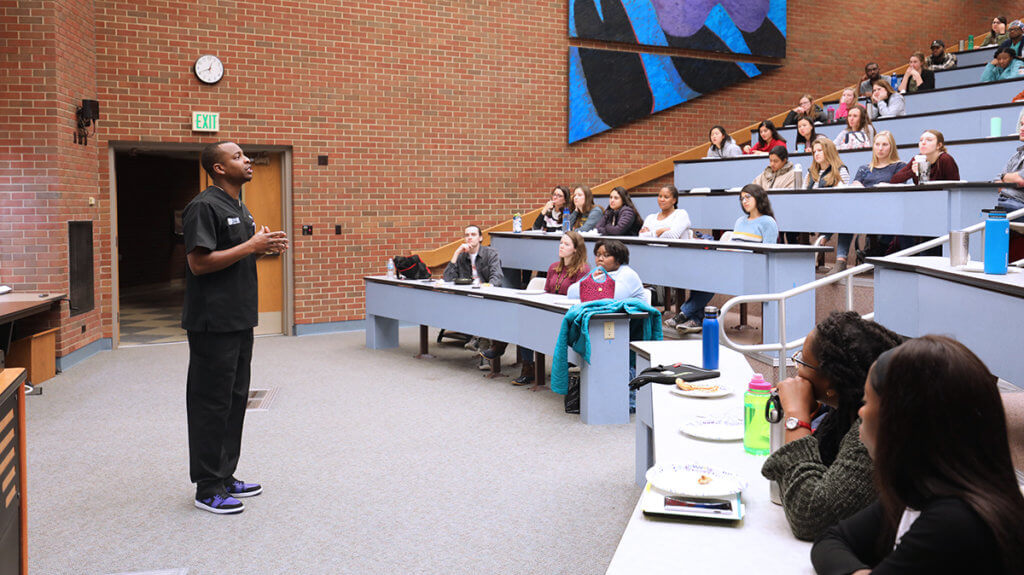 Dr. Blue speaks to students in a lecture room in Lynn Hall
