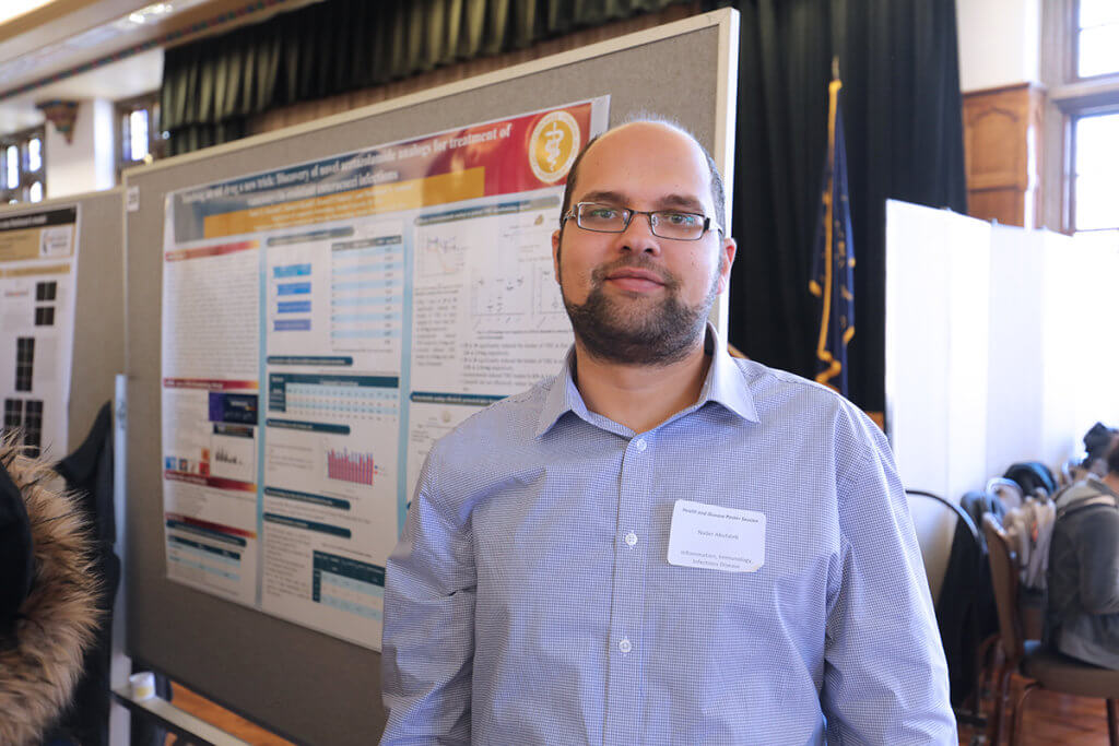 Nader stands in front of his research poster displayed in the Purdue Memorial Union ballroom