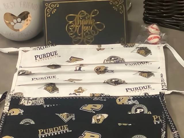 Purdue themed facemasks displayed next to a thank you card