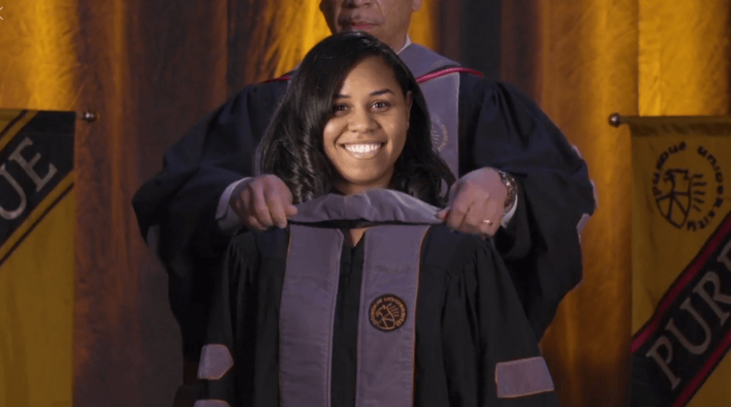 A screenshot of Dean Reed virtuallly hooding Dr. Evans