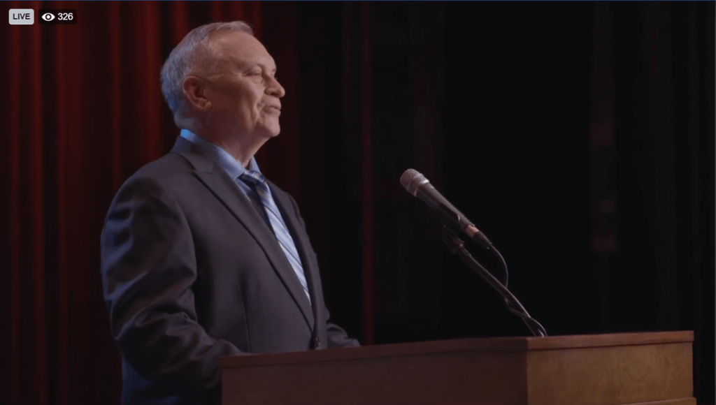 Dr. Baird speaks from behind a podium