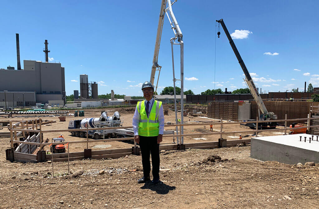 Dean Reed stands in the construction zone wearing a hardhat and neon vest