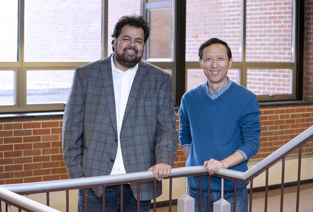 Dr. Chopra and Dr. Shi stand together along a staircase in Lynn Hall