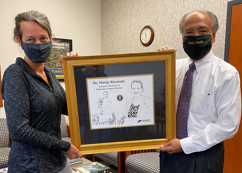 Dr. Risselada and Dean Reed hold up her framed illustration