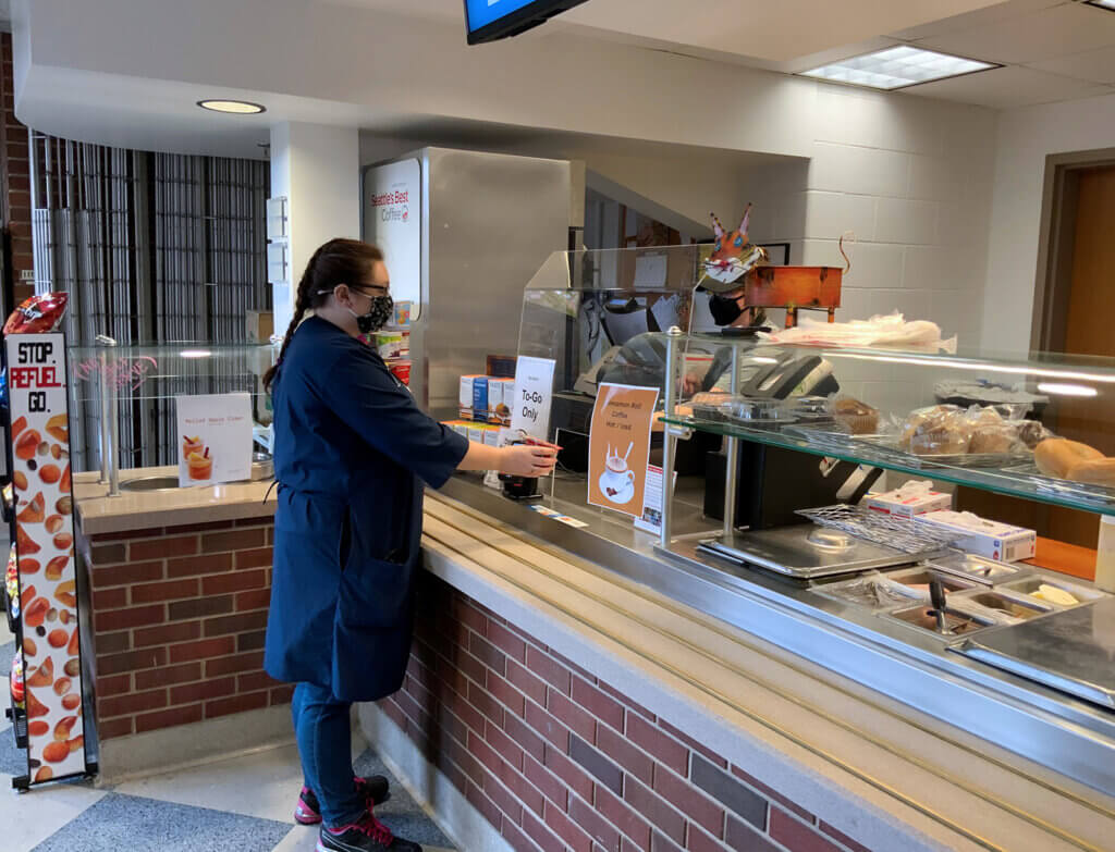 A student pays for her order at the cafe's counter