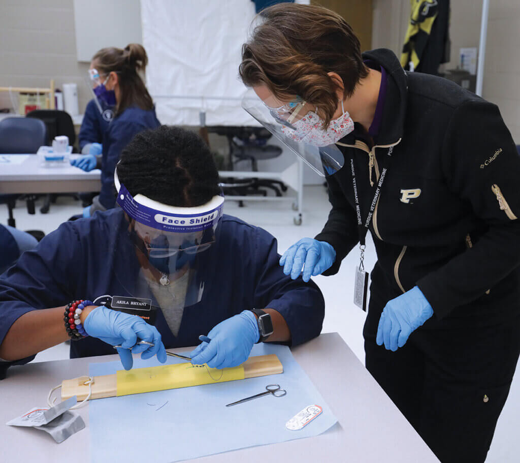 A student practices surgical skills as Dr. McGrady looks on