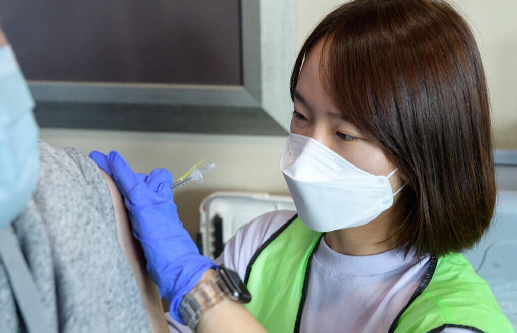 A Purdue Pharmacy student gives a vaccine shot at IU Health