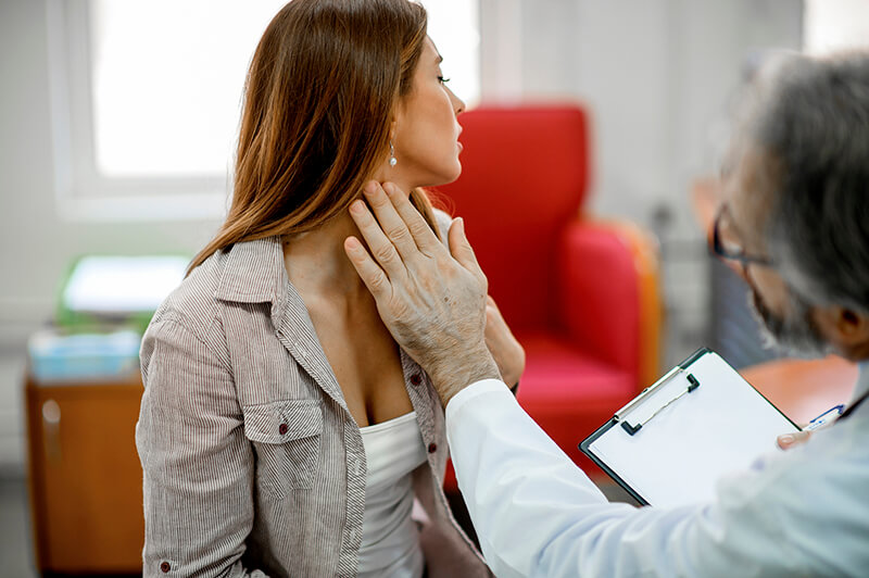 a doctor examines a woman's throat