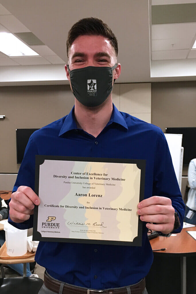 Aaron holds up his certificate