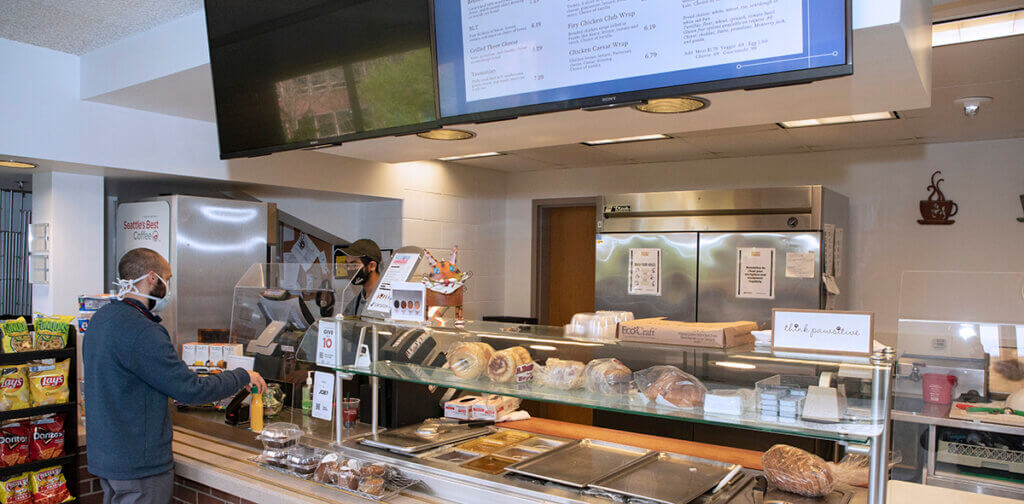 A customer at the cafe pays for his order at the register