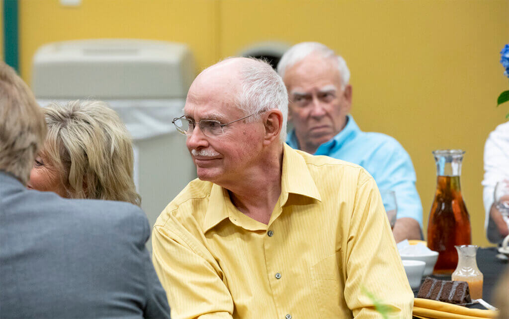 Dr. Ferguson smiles as he sits surrounded by classmates at the Beck Agricultural Center