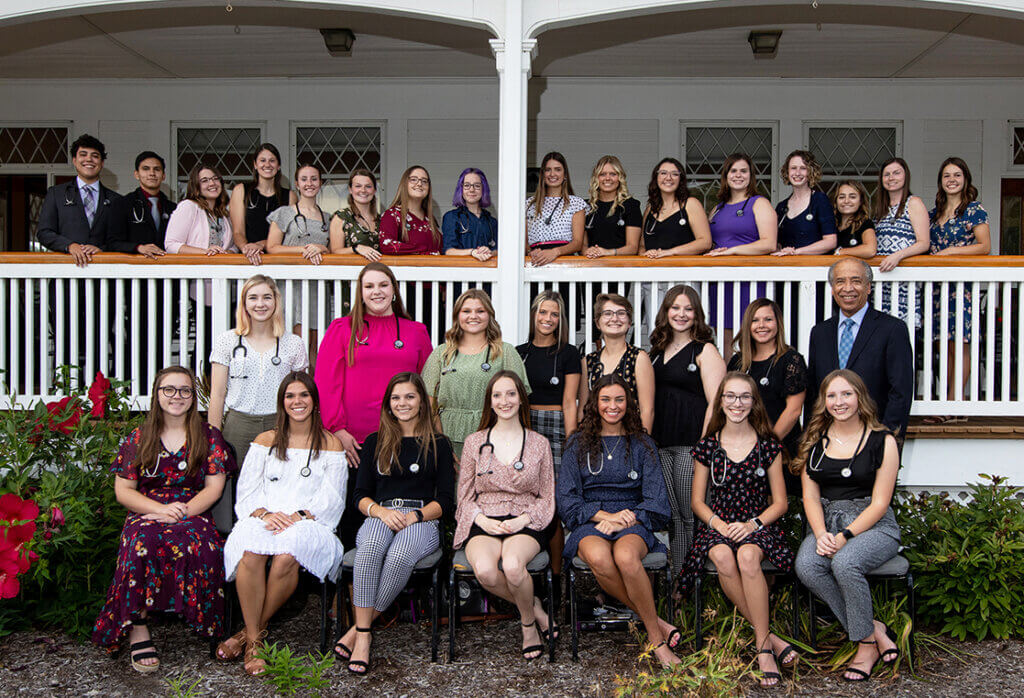 veterinary nursing students wear their new stethoscopes as they pose as a group