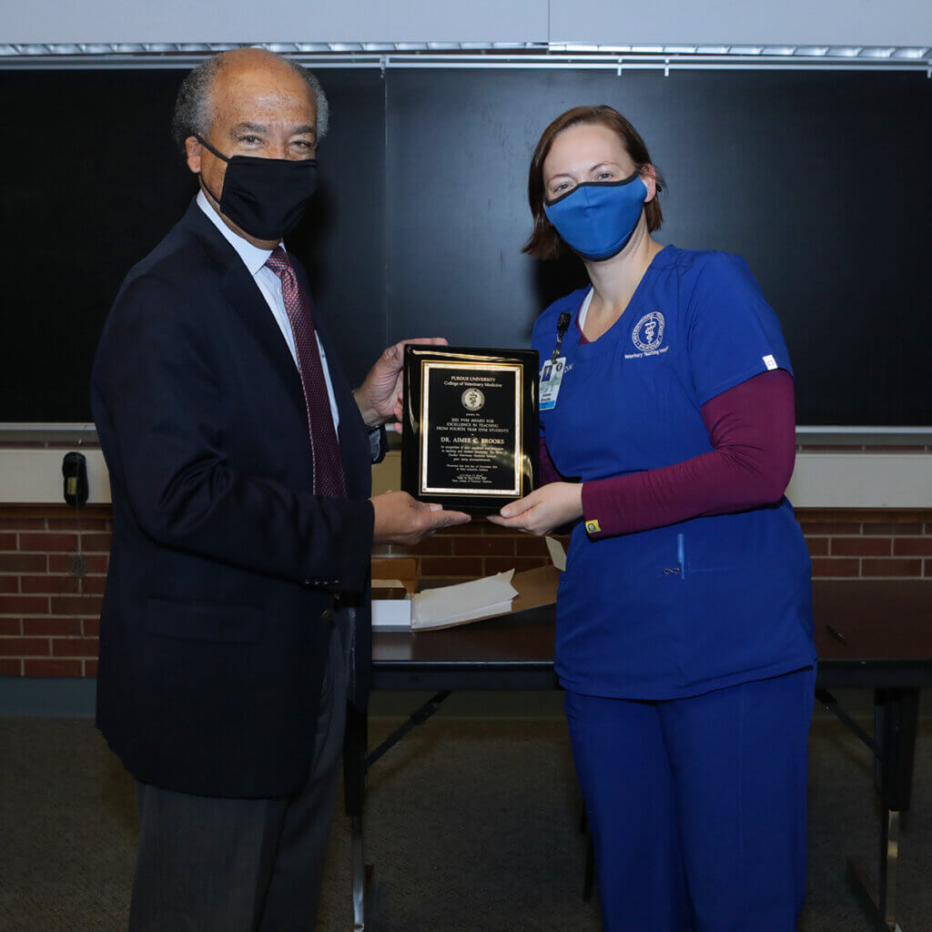 Dean Reed and Dr. Brooks hold up her award plaque