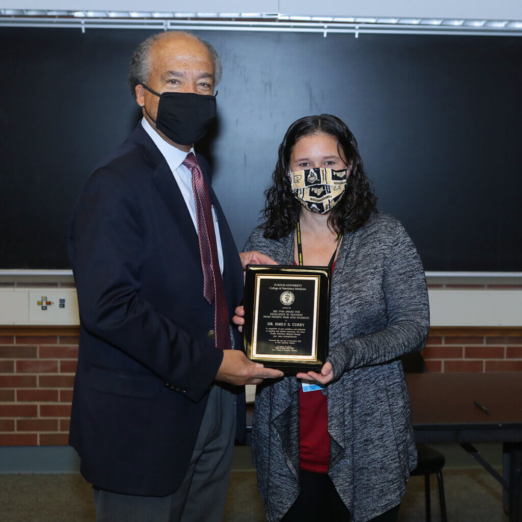 Dean Reed and Dr. Curry hold up her award plaque