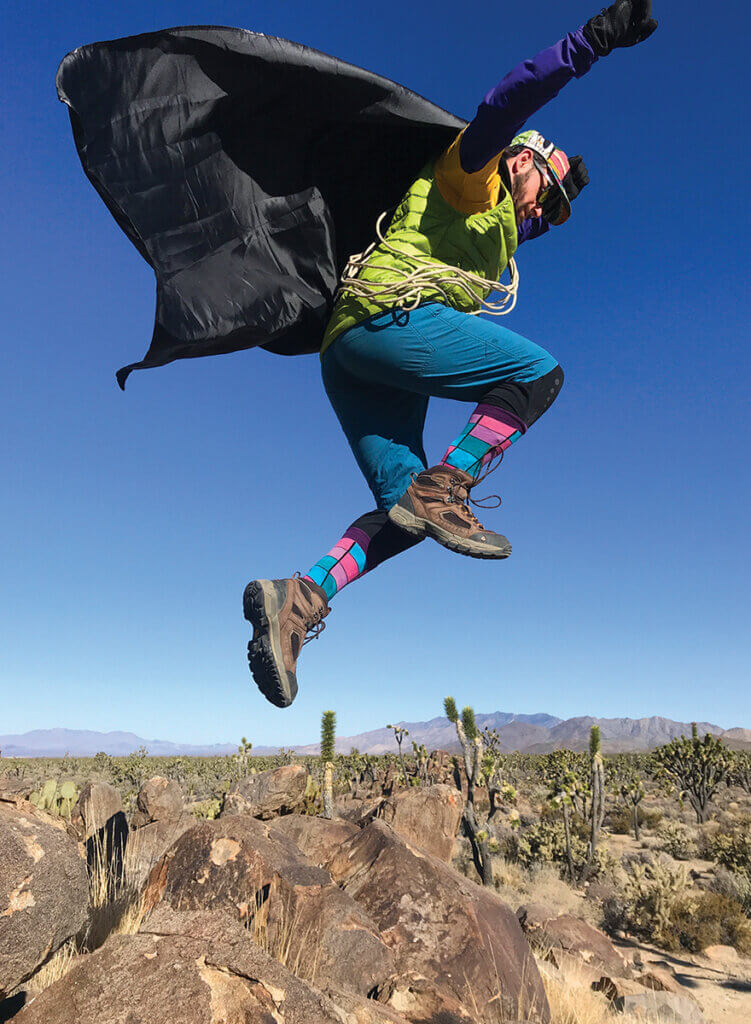Dr. Ortiz Leaping off a rock in the desert wearing his superhero cape