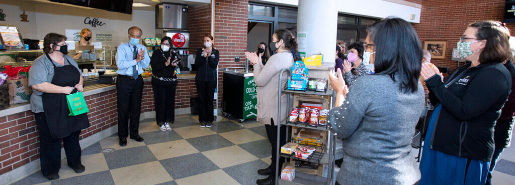 Staff and administrators join in applause for Tammie Hill in the Continuum Cafe