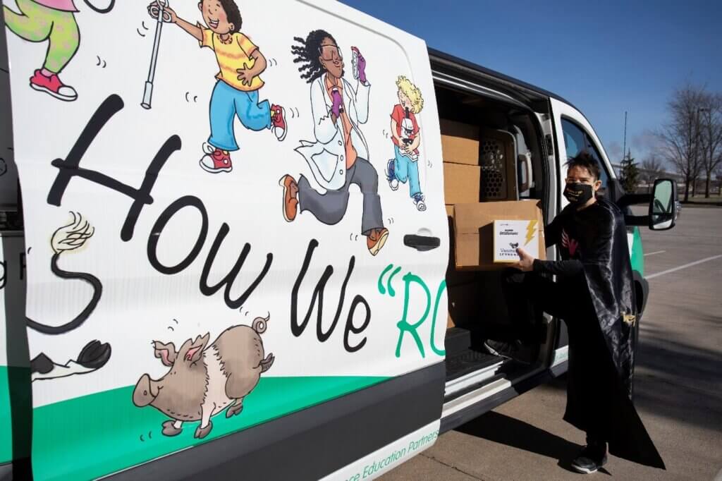 Dr. Sandy San Miguel, aka “Pink Phoenix,” the founder of the League of VetaHumanz and associate dean for engagement in the Purdue University College of Veterinary Medicine, displays one of the Vaccine SuperPower Packs being loaded into a van for delivery.