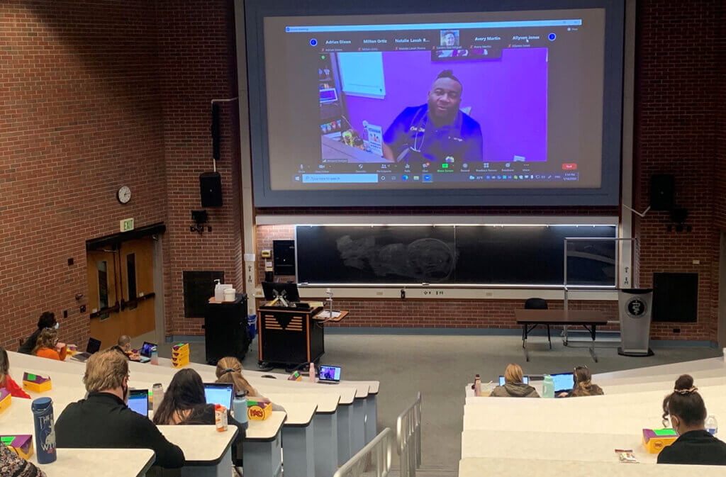 Students listen to Dr. Hodges via a virtual feed in Lynn Hall lecture room